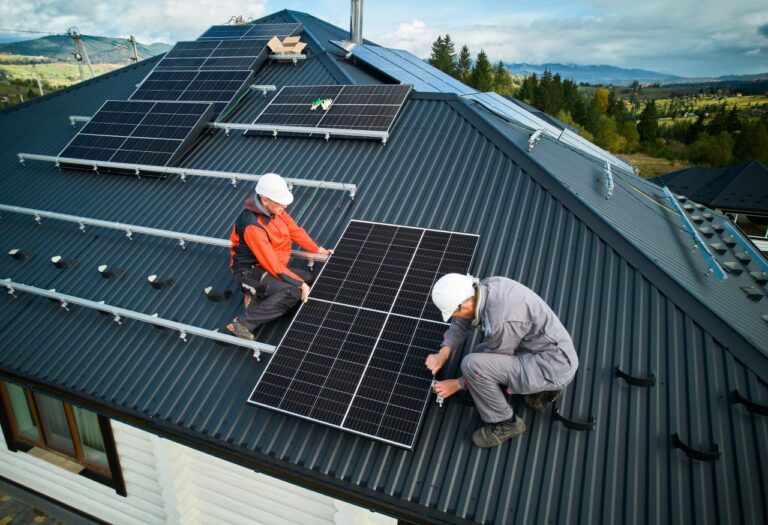 Electricians installing solar panels on a house roof ready for battery storage